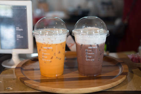 Cup of take away cold chocolate and cold Thai milk teaの写真素材