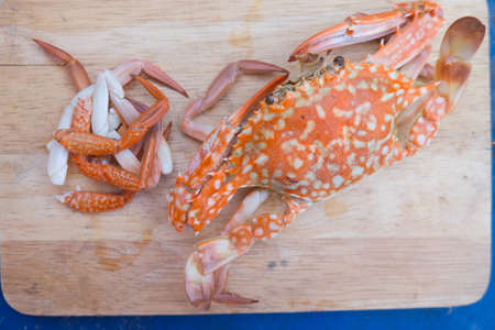 One steamed crab with claw separated on wood cutting boardの写真素材