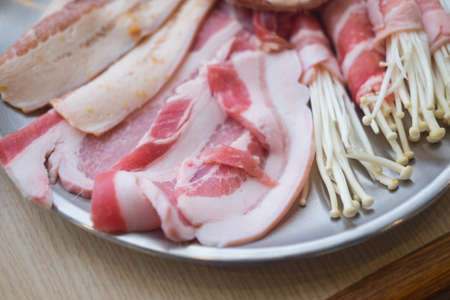 Raw fresh meat and enoki mushroom ready to cookの写真素材