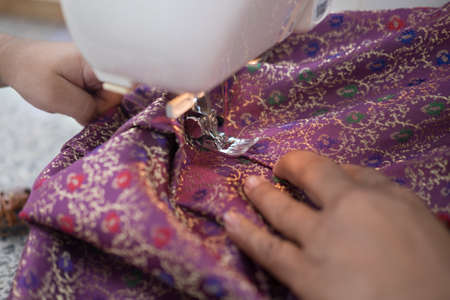 Female hands on sewing machine. Process of silk making. Close up