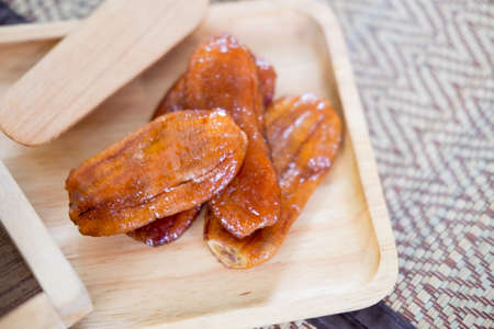 Sun dried banana on wooden plateの写真素材