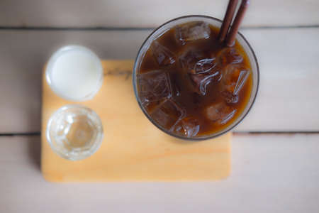Ice long black coffee in a glass served with maik and water