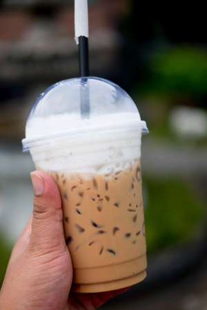 Cold iced coffee latte on hand. Cold summer drinkの写真素材