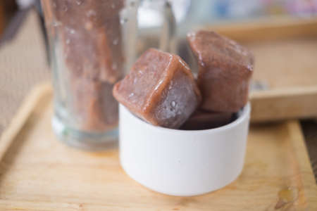Ice cubes made with cocoa in a glass to prepare refreshing summer drinks. (Homemade drink)