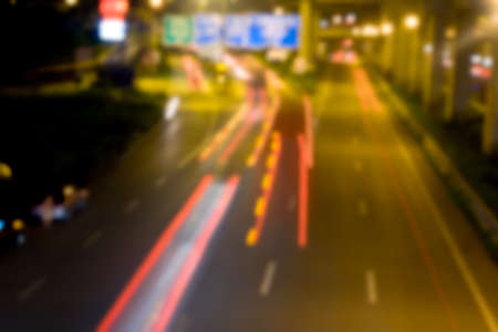 Motion blur car viewed from the road bridge in big modern city. Blurred road
