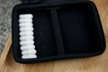 Herbal medicine capsules in black bag