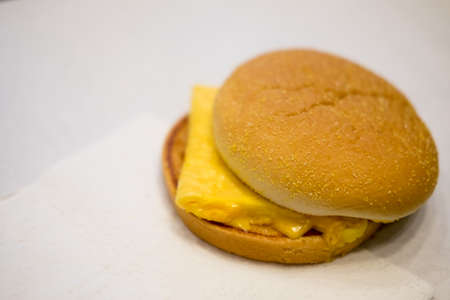 Homemade breakfast egg cheese muffin on white backgroundの写真素材