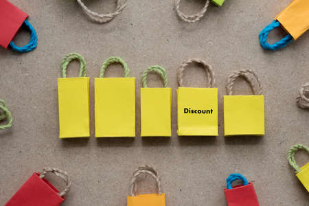Paper bag yellow shopping with text discount on bag. Special offer shopping time concept. Sales discount promotion.の写真素材