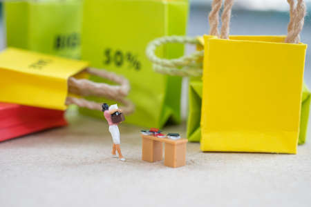 Women looking for shopping she work hard for relex to shopping. Concept of business for planning promotion in mid year (Miniature people)の写真素材