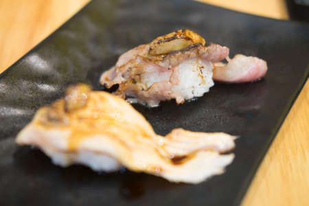 Sushi beef with cheese on black plate in restaurant.の写真素材