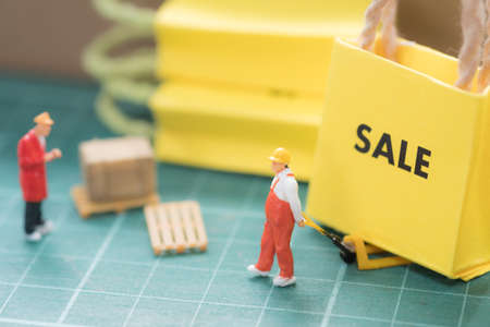Miniature worker move miniature sale bag shopping sent to buyer. Concept of shopping online or business online.の写真素材