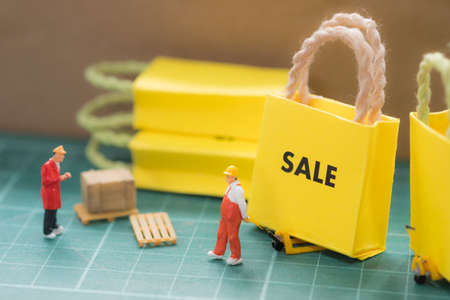 Miniature worker move miniature sale bag shopping sent to buyer. Concept of shopping online or business online.の写真素材