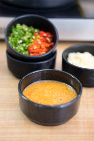 Sauces and condiments in black bowl for Shabu and Sukiyaki