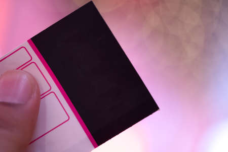 Hand holding ticket for special event with pink lighting backgroundの写真素材