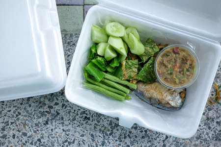 Mackerel fish chili spicy sauce with boiled vegetables put in foam box