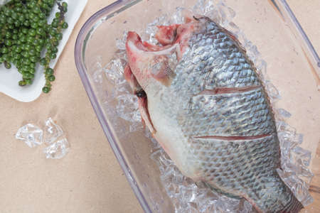 Raw tilapia fish in box for cooking with herbs, Thai food