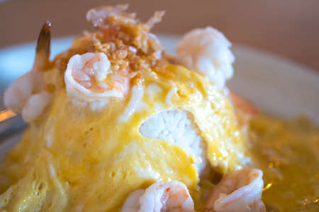 Rice and scrambled eggs topped with garlic and shrimpの写真素材