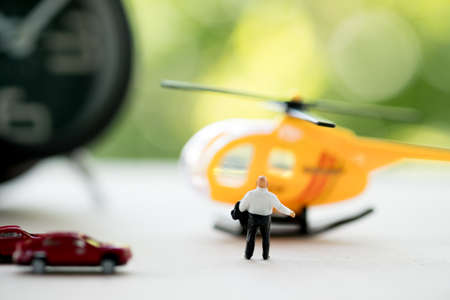 Rear view of miniature businessman walking towards helicopter. Businessman ready to pay for a...