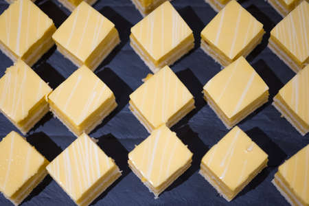 Delicious slice of yellow mango cake or fruit cake mango cake in sweet buffetの写真素材