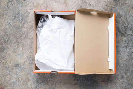 Opened shoes packaging cardboard box with crumpled wrapping paper top viewの写真素材