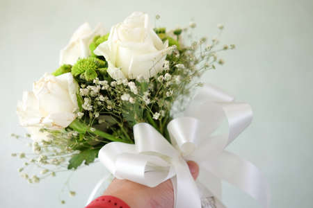 Wedding bouquet with white rose flowers in the handsの写真素材
