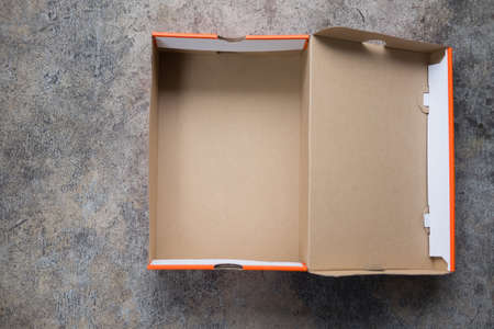 Open brown and orange cardboard box with lidの写真素材