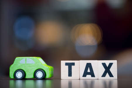 Wood cubes with word "TAX" and wooden toy car. Business concept of tax payments carの写真素材