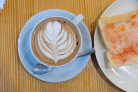 Fresh coffee with heart love foam in with cup and toastの写真素材