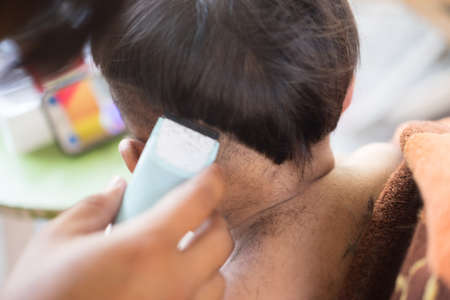 Baby boy haircut by his father. Close up portrait of toddler child getting his first haircutの写真素材