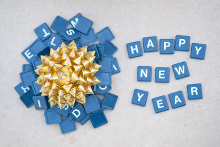 Text happy new years with gold bow against on wooden background. Concept background for happy new yearの写真素材