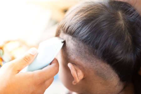 Father is making haircut to boy in home. first time haircutの写真素材