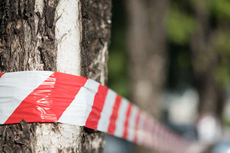 Red and white striped tape defining the border of a dangerous zone of construction work in process