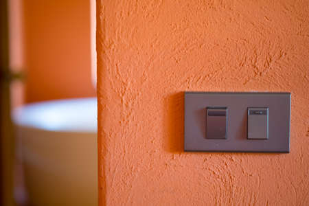 Light electricity switch mounted on orange wall, home decoration conceptの写真素材