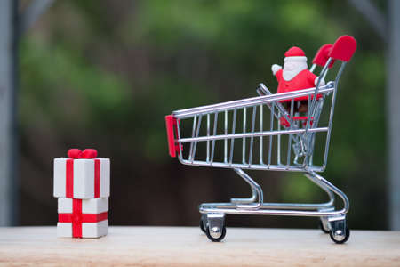 Shopping cart with Santa claus and Christmas present. Christmas sale conceptの写真素材