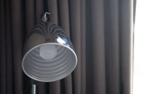 Table lamp with gray curtain. Interior of modern house