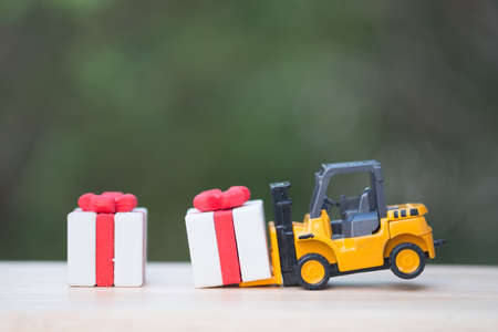 Toy forklift truck with christmas gift box. Delivering presents conceptの写真素材