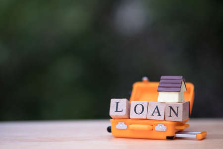 Mini house model in orange luggage. concept of mortgage  real estate property.  Loan for a mortgage homeの写真素材