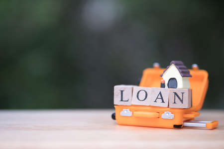 Mini house model in orange luggage. concept of mortgage  real estate property.  Loan for a mortgage homeの写真素材