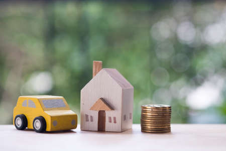 Wooden home, car with coins. Property mortgage, financial or insurance house, essentials for life ideasの写真素材