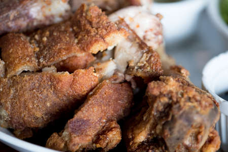 Crispy fried pork leg placed on a plate with seasoning sauceの写真素材