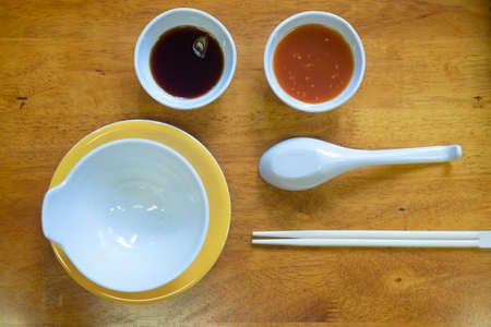 Flat lay of stylish dining set arrangement for shabu shabu with sauce and condimentsの写真素材