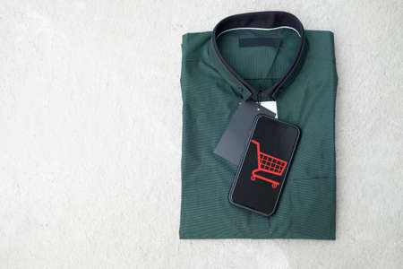Smart mobile phone with online shopping store put on man green shirt. Business internet shop online conceptの写真素材