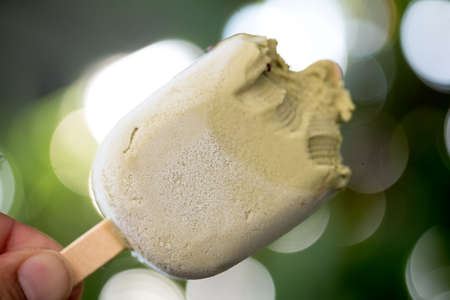 Holding Bitten popsicle with matcha tea