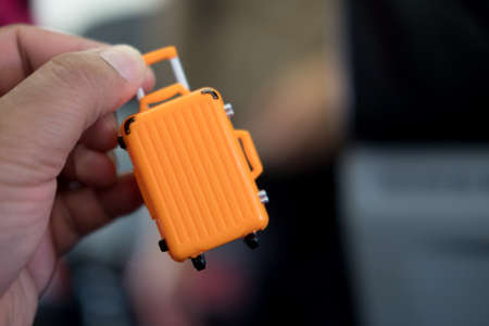 Miniature of orange suitcase in hand : ready for travelの写真素材