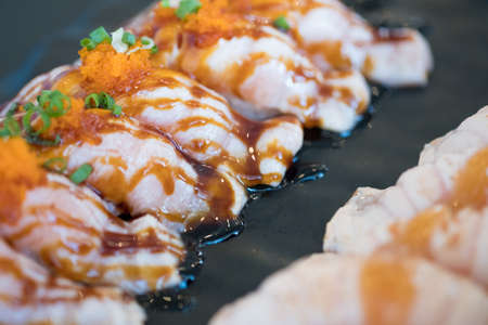 Grilled or burned salmon sushi with sweet sauce  (selective focus)の写真素材