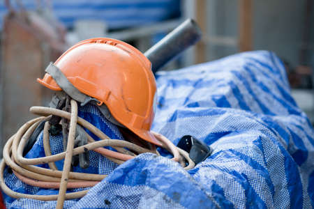 protective orange helmet lies on a black board, used in construction for safety and head protection, closeupの写真素材