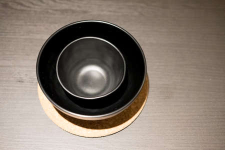 Top view of black empty bowls on wooden backgroundの写真素材