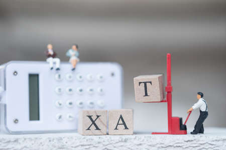 Lift forklift wood word with TAX. Concept of pay annual income (TAX) for the year  great way to grow. using as background business concept and finance conceptの写真素材