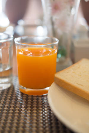Glass of orange juice on the breakfast tableの写真素材