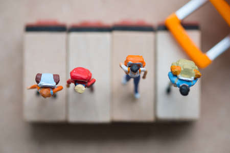 Group miniature traveler and hiker backpack standing on wooden tag with suitcase for the tourist and adventure around the world. Travel and tour conceptの写真素材